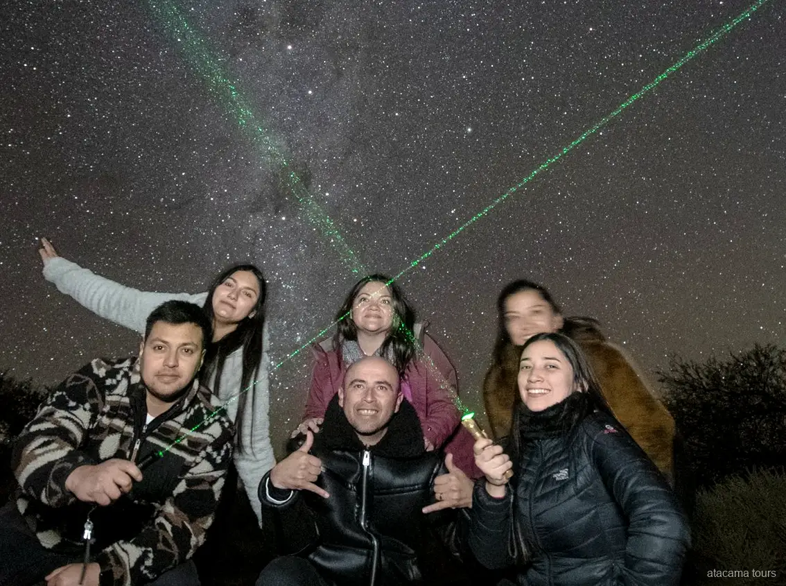 Atacama stargazing tours, lachende groep poseert onder de nachthemel met groene laserstralen