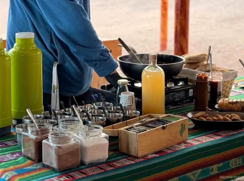 Collation des excursions dans l'Atacama : thermos, bocaux, pain et réchaud sur une nappe andine rayée